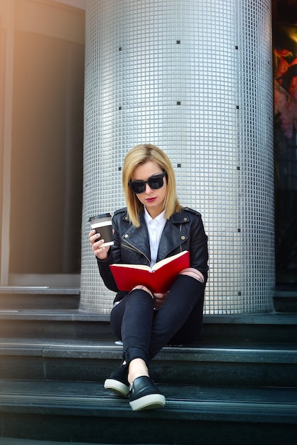 Ragazza con il libro di lettura del caffè