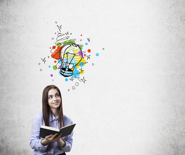 Ragazza con il libro e lo schizzo della lampadina