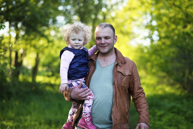 Ragazza con il padre nel parco la sera di una giornata di sole in primavera