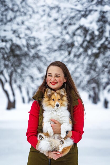 Ragazza con il suo cane nel parco invernale.