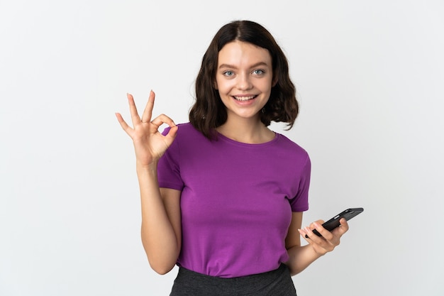 Ragazza con il telefono su bianco isolato