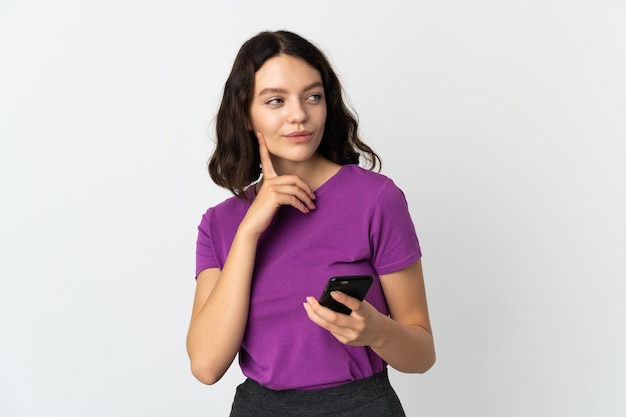 Ragazza con il telefono su bianco isolato