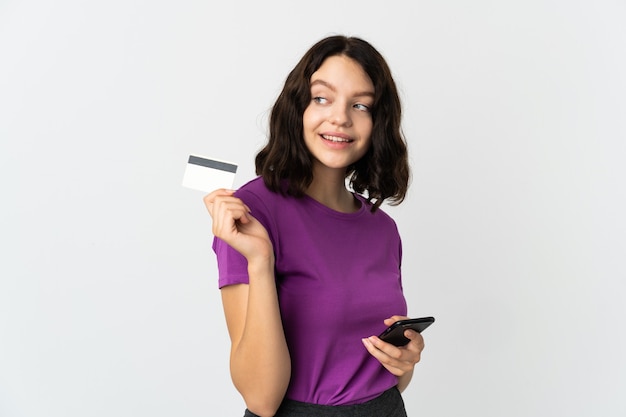 Ragazza con il telefono su bianco isolato