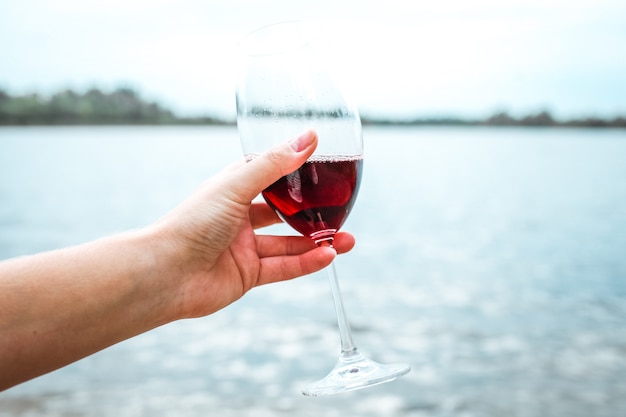 Ragazza con in mano un bicchiere di vino rosso