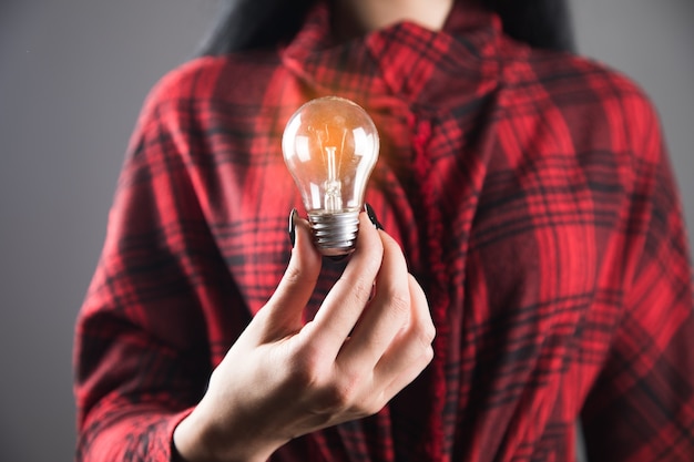 Ragazza con in mano una lampadina