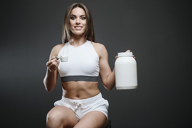 Ragazza con integratore di siero di latte in polvere