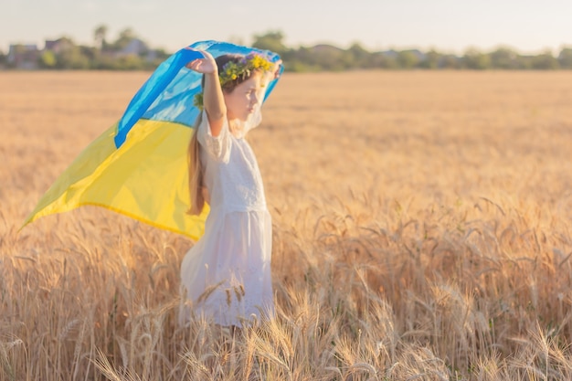 Ragazza con la bandiera nazionale ucraina in sfocatura.