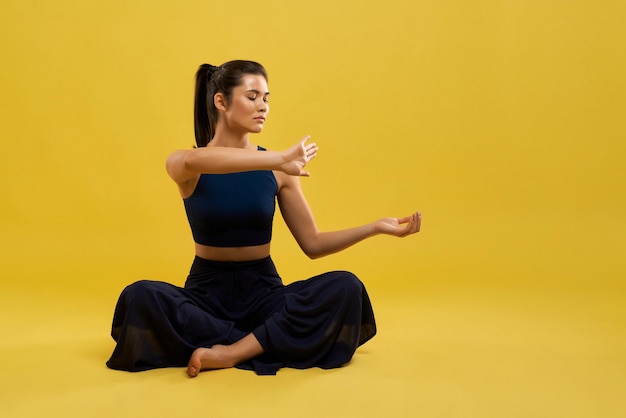 Ragazza con la coda di pony seduta a fare yoga