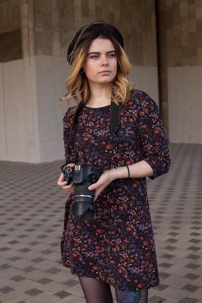 Ragazza con la fotocamera digitale che guarda da parte