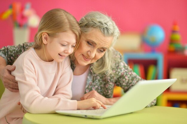 Ragazza con la nonna che usa il computer portatile