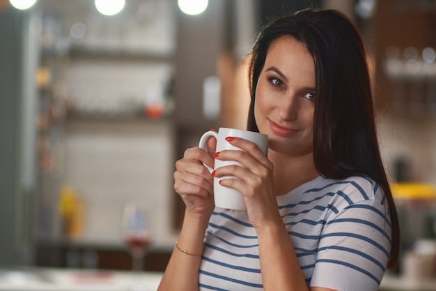 Ragazza con la tazza bianca nelle mani