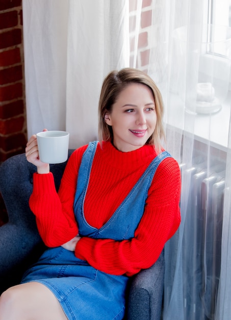 Ragazza con la tazza di caffè a casa