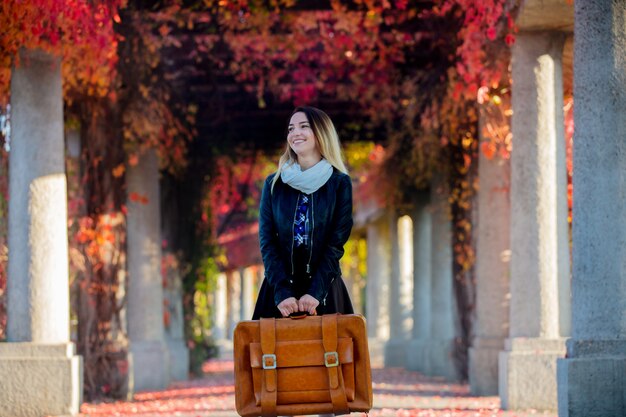 Ragazza con la valigia in vicolo dell'uva rossa