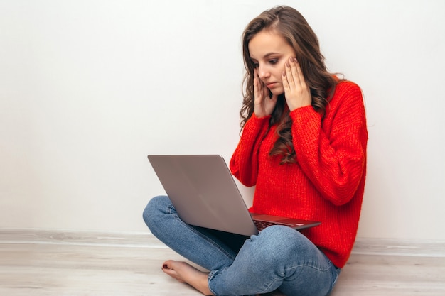 Ragazza con laptop e telefono a casa.