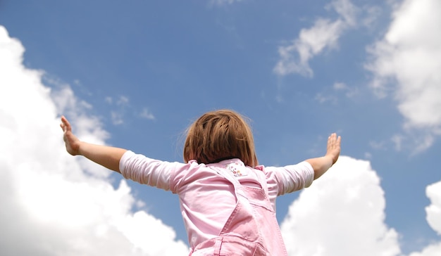 ragazza con le braccia spalancate e sfondo con cielo (valori multipli)