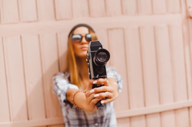 Ragazza con le braccia tese con una videocamera antico