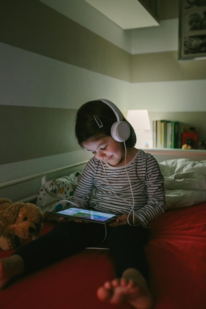 Ragazza con le cuffie guardando il tablet