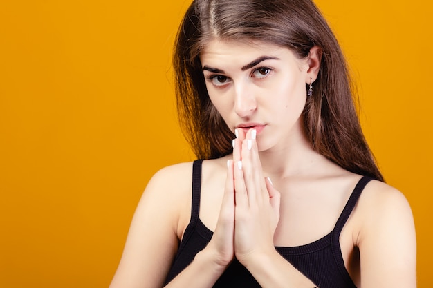 Ragazza con le mani giunte che chiedono aiuto o perdono