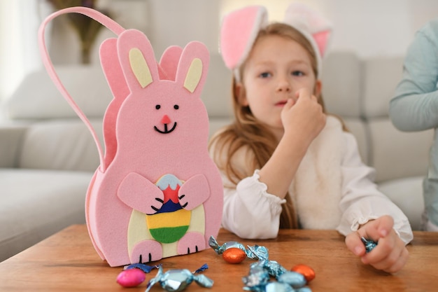 Ragazza con le orecchie di coniglio e il cesto per le uova di cioccolato di Pasqua