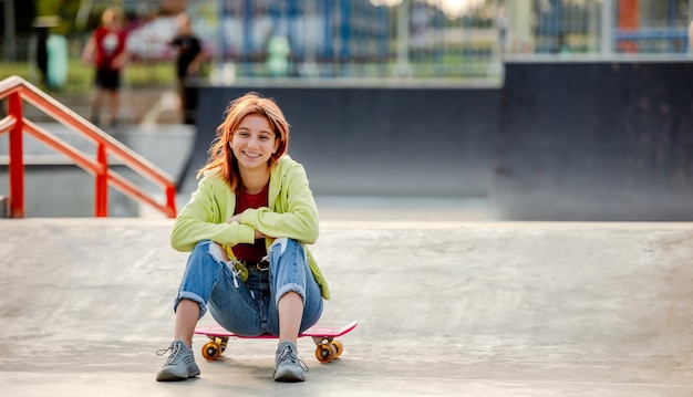 Ragazza con lo skateboard all'aperto