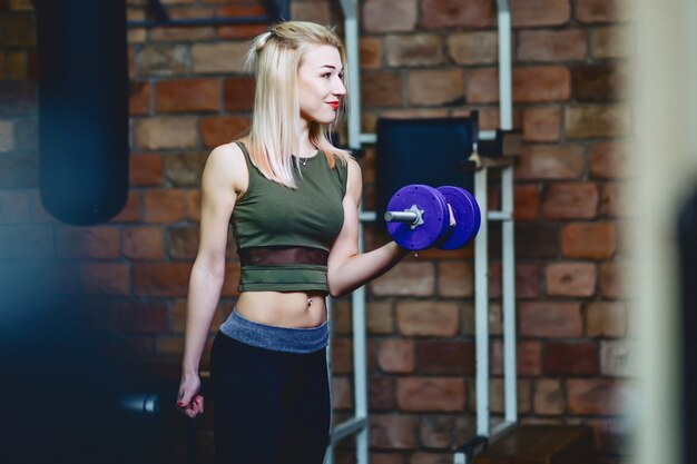 Ragazza con manubri in palestra