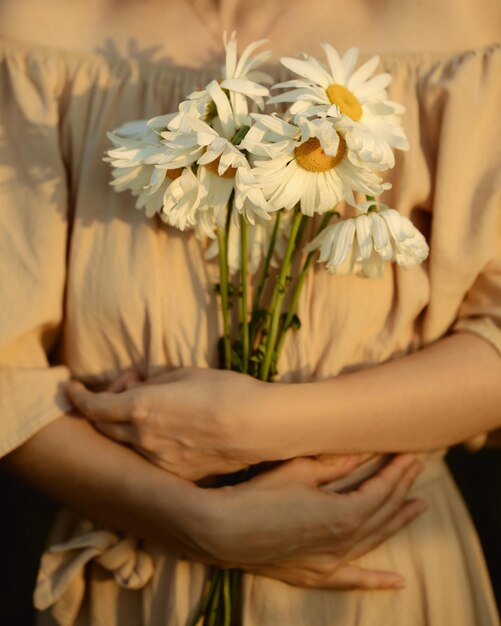 Ragazza con margherite La donna stringe al petto un mazzo di fiori