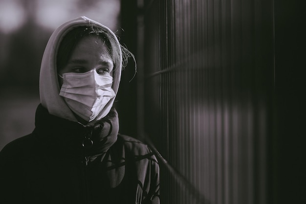 ragazza con maschera medica nella zona di quarantena COVID19 foto in bianco e nero