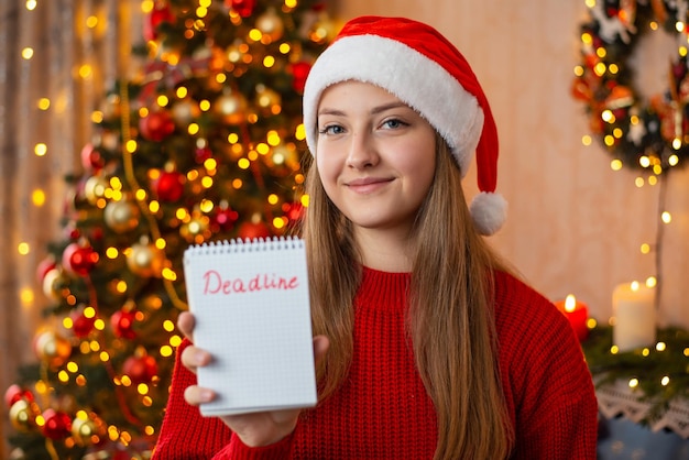 Ragazza con note di scadenza nel soggiorno decorato Festa di Natale che svolge attività prima del nuovo anno
