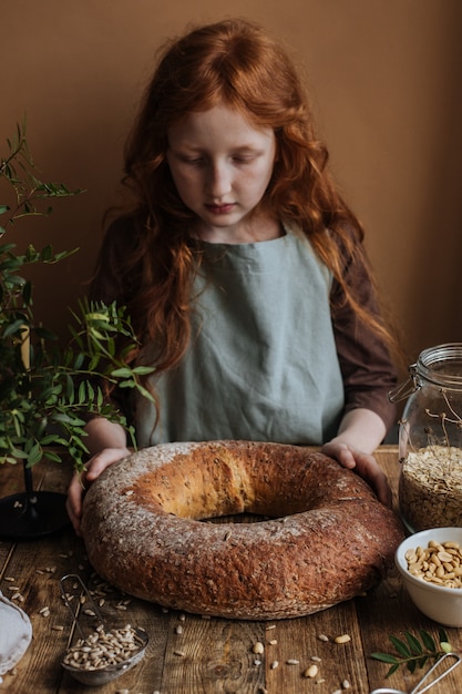 Ragazza con pane tondo al forno