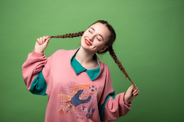 Ragazza con pezzi di rossetto rosso in un'uniforme sportiva su sfondo verde chiaro