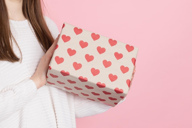 Ragazza con regalo con cuori su sfondo rosa concetto di san valentino