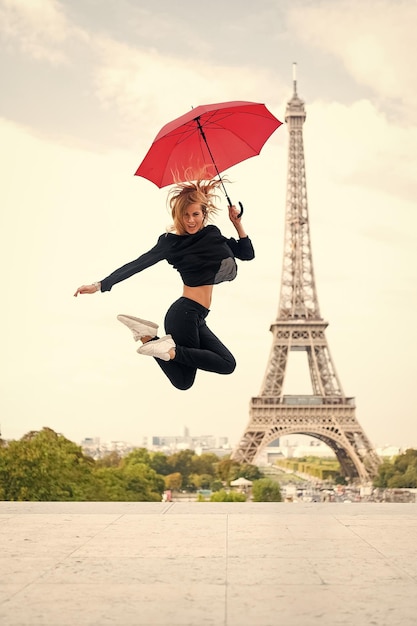 Ragazza con sguardo di bellezza alla torre eiffel Donna salto con ombrello moda parigino isolato su sfondo bianco Donna felice viaggio a parigi francia Viaggiare e voglia di viaggiare Godetevi le vacanze estive