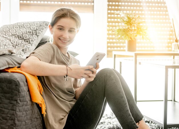 Ragazza con smartphone a casa