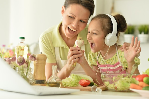 ragazza con sua madre che cucina insieme al tavolo della cucina