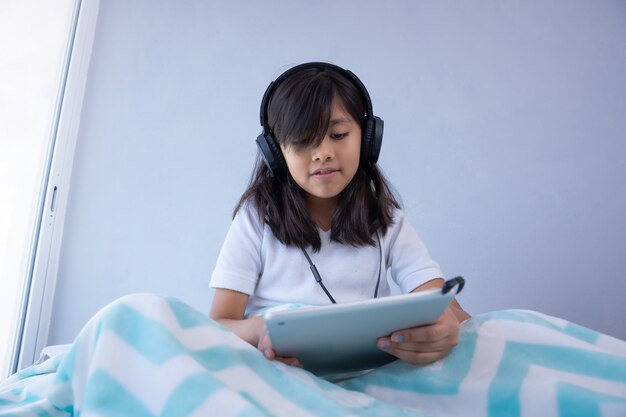 Ragazza con tablet e cuffie in quarantena