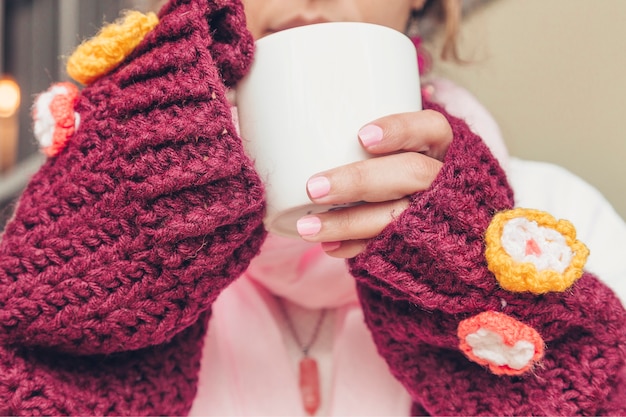 Ragazza con tazza bianca, bevanda calda e deliziosa