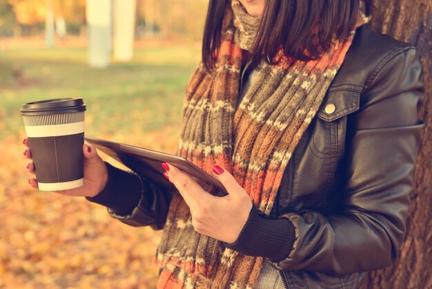 Ragazza con tazza di caffè e tablet