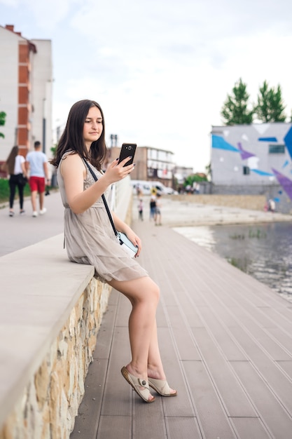 Ragazza con telefono sul molo.