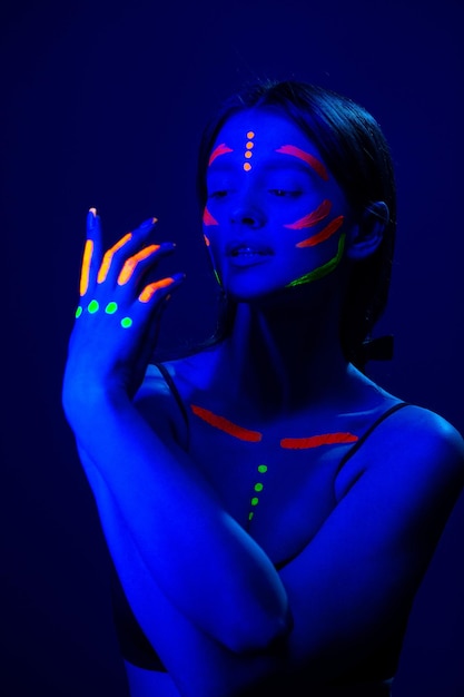 Ragazza con trucco fluorescente sul viso e sul petto