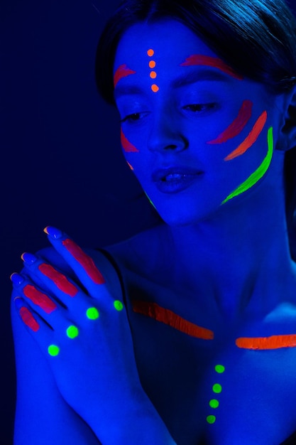 Ragazza con trucco ultravioletto in luce al neon