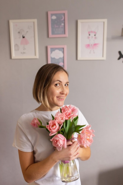 Ragazza con tulipani rosa in un vaso di vetro 8 marzo Compleanno di San Valentino