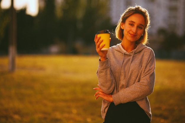 ragazza con un caffè ragazza beve lat da un bicchiere di carta per strada elaborazione di foto vintage