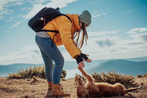 Ragazza con un cane gioca in montagna Umore autunnale Viaggiare con un animale domestico Donna e il suo cane in posa all'aperto