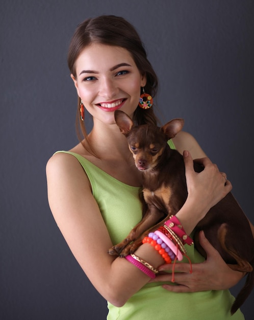 Ragazza con un cane su sfondo grigio