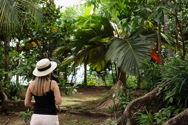 ragazza con un cappello sullo sfondo dei tropici