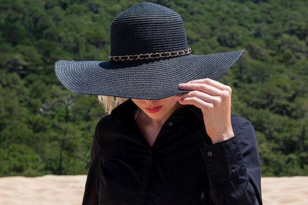 Ragazza con un grande cappello in natura