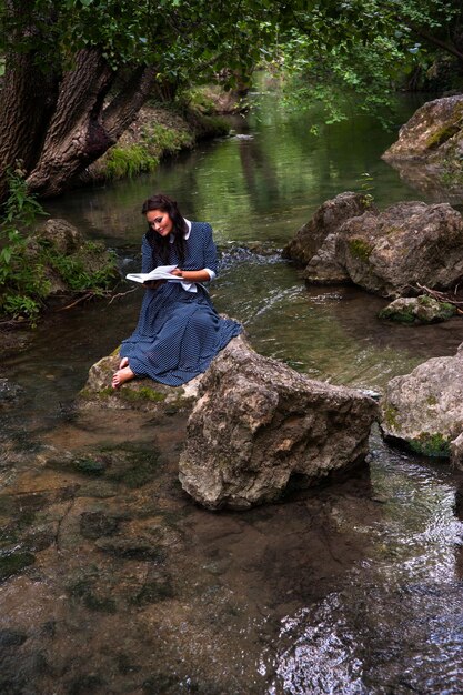 ragazza con un libro sul fiume