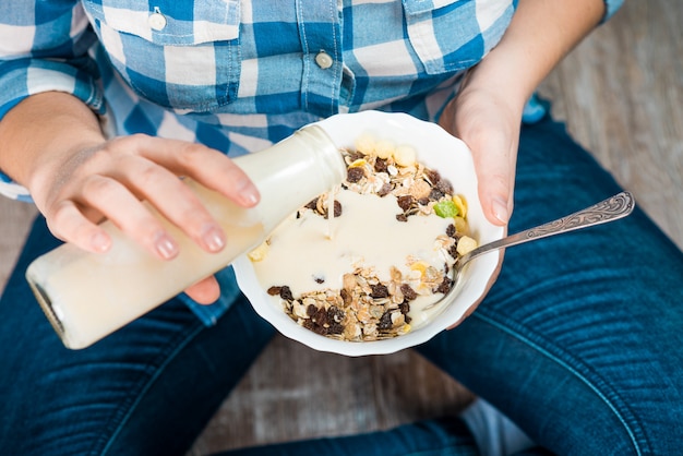 Ragazza con un piatto di cereali integrali con yogurt