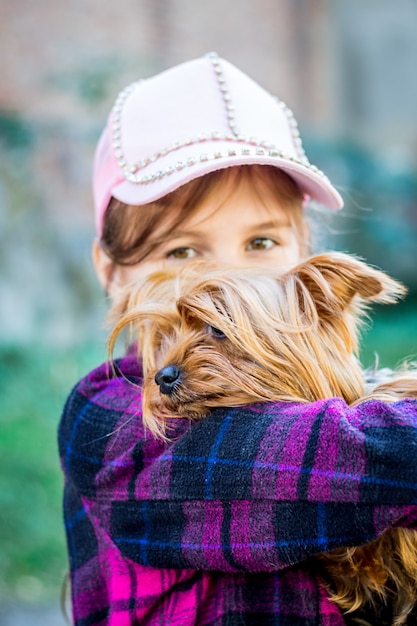 Ragazza con un piccolo cane di razza Yorkshire Terrier in braccio