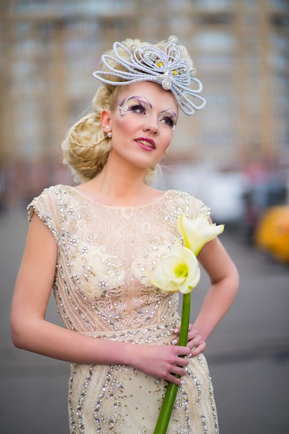 Ragazza con un trucco originale in un bellissimo vestito con fiori